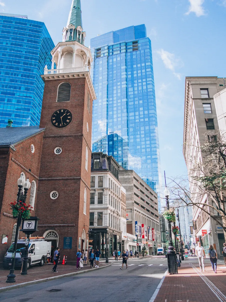 a tall clock tower towering over a city filled with tall buildings